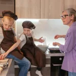 Elderly woman and children cooking together, fostering family bonding.