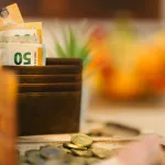 A wallet sitting on top of a table filled with money